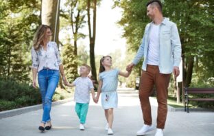 Casal caminhando com filhos em parque em Moema.