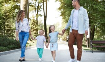 Casal caminhando com filhos em parque em Moema.
